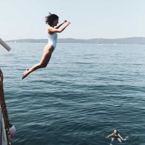 girl jumps into ocean