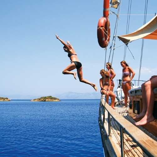 friends jump of sailing boat