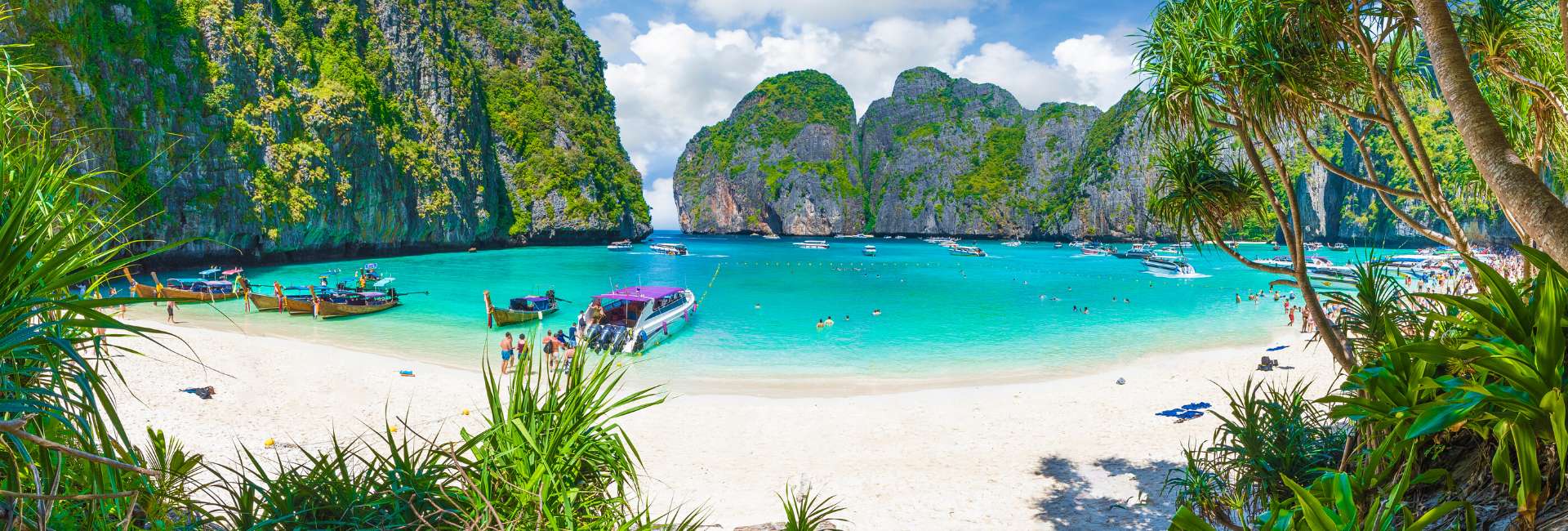 Thailand beach with boat and people swimming