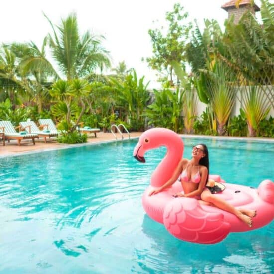 Woman on flamingo Lilo in the pool