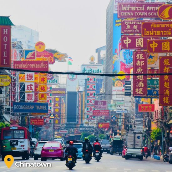 Motorbikes and cars on chinatown street in Bangkok Thailand