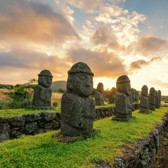 Moai statues against sunset backdrop