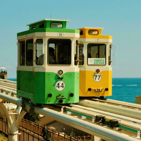 Two colorful trams above ocean